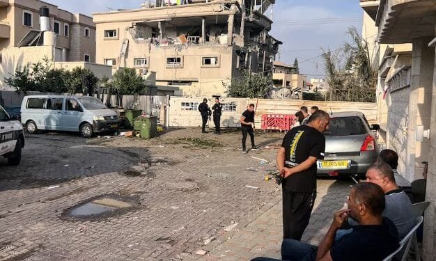 Warga dan polisi berkumpul di dekat sebuah rumah yang terkena serangan proyektil Lebanon di kota Tira, Israel tengah, Sabtu (02/11/2024).(Reuters)