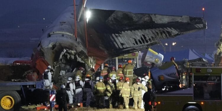 Tim penyemalat sedang memindahkan bagian badan pesawat Jeju Air yang terbakar, Minggu (29/12/2024).(APNews)