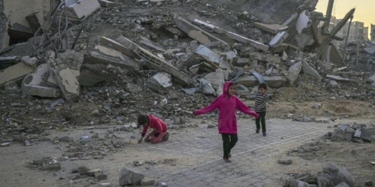 Anak-anak bermain dii samping reruntuhan bangunan di Jalur Gaza yang diserang militer Israel.(APNews)