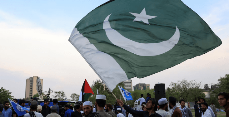 Seorang pria mengibarkan bendera Pakistan sebagai bentuk dukungan kepada tentara Pakistan, sehari setelah pengumuman gencatan senjata antara India dan Pakistan, di Islamabad, Pakistan, 11 Mei 2025.(Reuters)