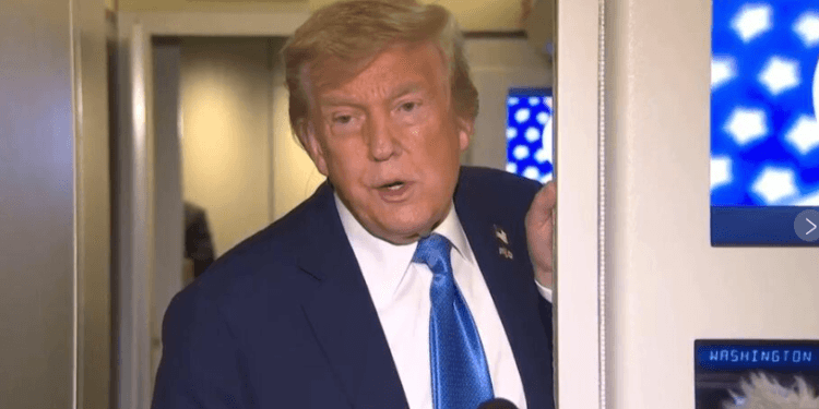 Donald Trump di berbicara di pintu pesawat Air Force One.(APNews)